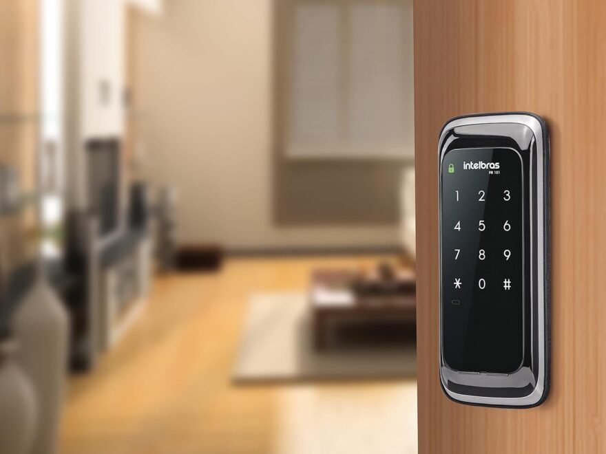 Fechadura digital de sobrepor Intelbras FR 101 preta com teclado touch screen instalada em porta de madeira.